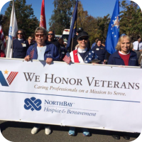 Hospice volunteers marching in a parade that celebrated veterans.