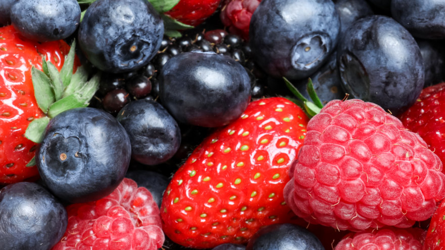 Close up image of plump and vibrant blueberries, strawberries and raspberries. Whether frozen or fresh, berries are a great source of fiber!