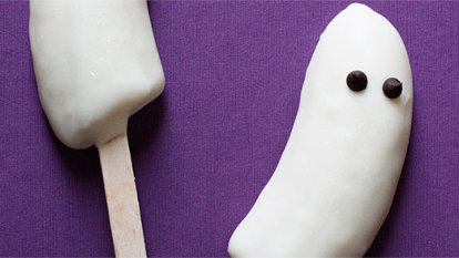 Bananas covered in white chocolate to look like ghosts with two chocolate dots for eyes.
