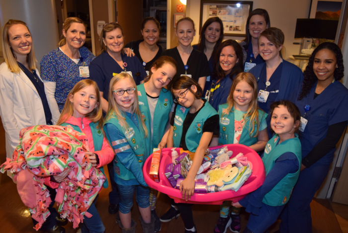 A team of Girl Scouts including Laila McGovern, Emma Christofferson, Amy Borchert, Ayana Elias, Caitlin McGee and Lily Coble, pose with members of the Women and Children’s Services Department for a photo.