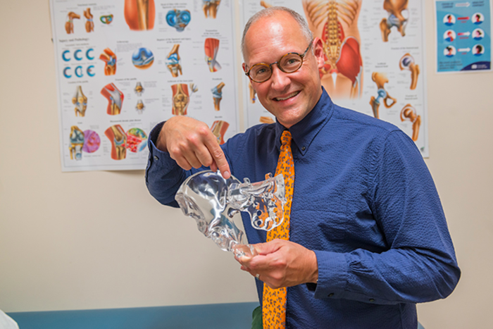 Orthopedic specialist Cornelis Elmes, M.D., points to the sacroiliac joint on a model.