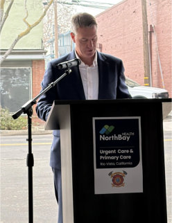 CEO of NorthBay Health, Mark Behl, giving a speech in front of a podium.