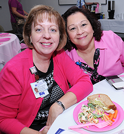 Louise Henry (left) and Bea Castro of the NorthBay Cancer Center staff support the luncheon by wearing pink.